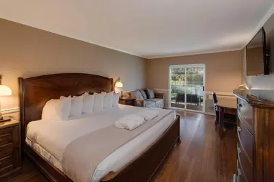 a bedroom with a large bed with white pillows at South Thompson Inn & Conference Centre in Kamloops