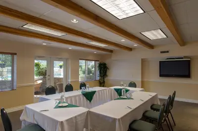 a conference room with tables and chairs and a flat screen tv at South Thompson Inn & Conference Centre in Kamloops