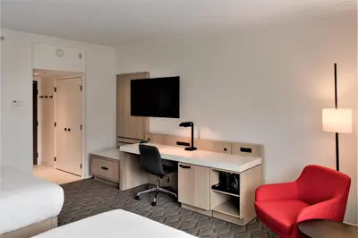 a hotel room with a desk and a red chair at Delta Hotels by Marriott Kamloops in Kamloops