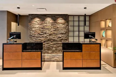 a lobby with two reception desks and a stone wall at Delta Hotels by Marriott Kamloops in Kamloops