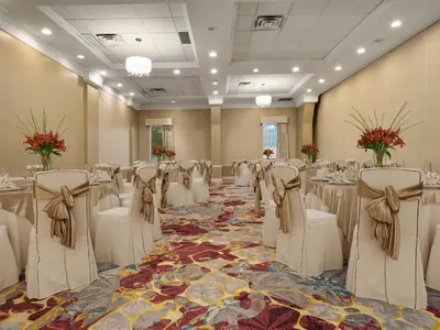 a banquet hall with white chairs and tables in a room at Holiday Inn Conference Centre Edmonton South by IHG in Edmonton