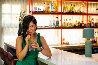 a woman sitting at a bar drinking a drink at Buffalo Mountain Lodge in Banff