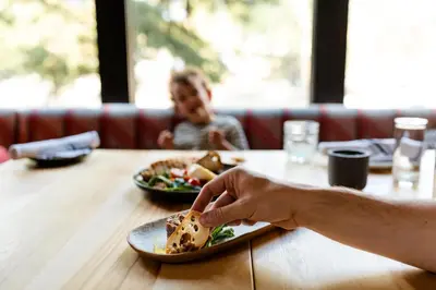 a person sitting at a table with a plate of food at Buffalo Mountain Lodge in Banff
