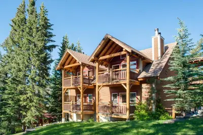 a large log home with a wrap around deck at Buffalo Mountain Lodge in Banff