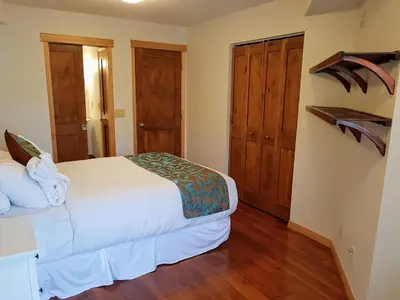 a bedroom with a bed with wooden floors and wooden doors at PRC Annex - Pet Friendly in Canmore