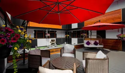 a patio with a table and a red umbrella at Coast Metro Vancouver Hotel in Burnaby