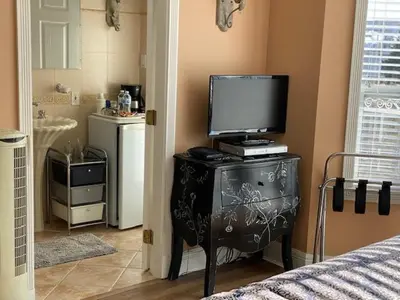 a bedroom with a television on a dresser with a bed at Ocean Breeze Executive Bed and Breakfast in North Vancouver