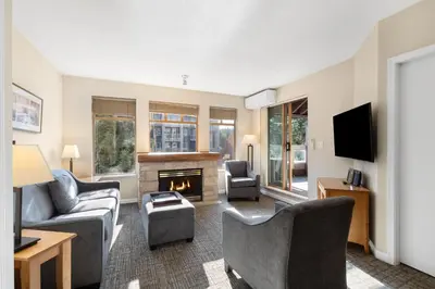 a living room with a couch and chairs and a fireplace at Tyndall Stone Lodge by Whiski Jack in Whistler