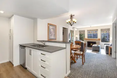 a kitchen with a sink and a dining room at Tyndall Stone Lodge by Whiski Jack in Whistler