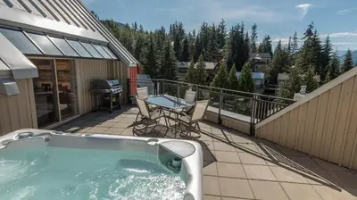a hot tub on the balcony of a house at Lake Placid Lodge by Whiski Jack in Whistler