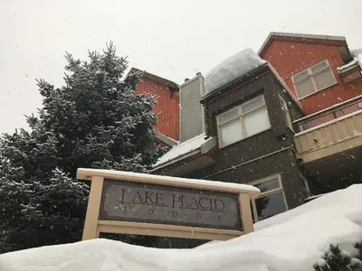 a sign in the snow in front of a building at Lake Placid Lodge by Whiski Jack in Whistler