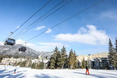 a person on skis in the snow next to a ski lift at The Woodrun Lodge by Whiski Jack in Whistler