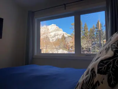 a bedroom with a window with a mountain view at Mountain View Bed & Breakfast in Banff