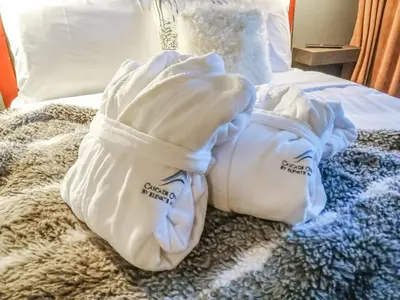 two white towels sitting on top of a bed at Cascade Lodge by Elevate Vacations in Whistler