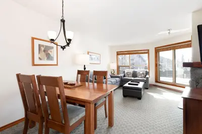 a dining room with a table and a couch at The Aspens by Whiski Jack in Whistler