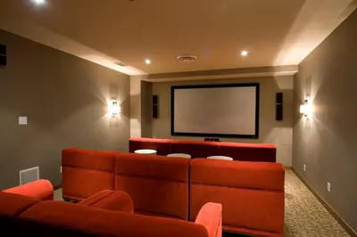 a waiting room with orange couches and a projection screen at Evolution Whistler, by Lodging Ovations in Whistler