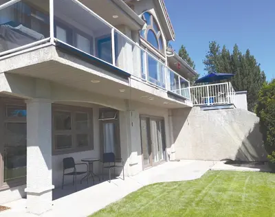 a house with a balcony and a table and chairs at Quail Ridge in Kelowna