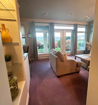 a living room with a couch and a large window at Quail Ridge in Kelowna