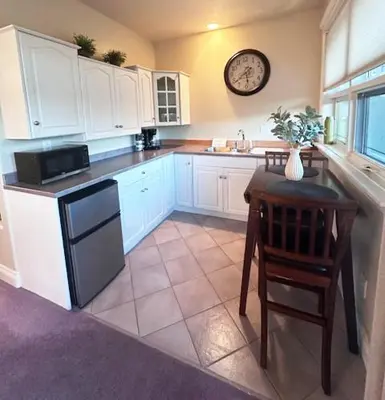 a kitchen with a table and a clock on the wall at Quail Ridge in Kelowna