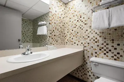 a bathroom with a sink and a toilet at Travelodge by Wyndham Grande Prairie in Grande Prairie