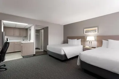 a hotel room with two beds and a kitchen at Travelodge by Wyndham Grande Prairie in Grande Prairie