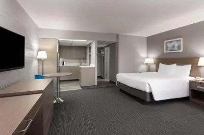 a hotel room with a bed and a kitchen at Travelodge by Wyndham Grande Prairie in Grande Prairie