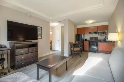 a living room with a couch and a table in a room at Coast Calgary Downtown Hotel & Suites by APA in Calgary