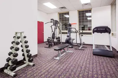 a gym with several treadmills and tread machines at Ramada by Wyndham Red Deer Hotel & Suites in Red Deer