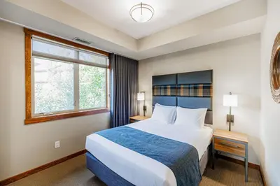 a hotel room with a large bed and a window at Stoneridge Mountain Resort in Canmore