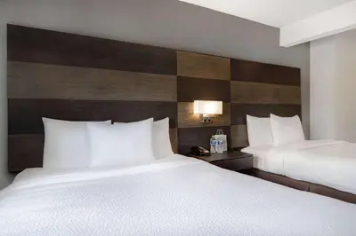 a hotel room with two beds with white pillows at Days Inn by Wyndham Calgary South in Calgary