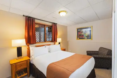 a hotel room with a bed and a chair at Overlander Mountain Lodge in Jasper