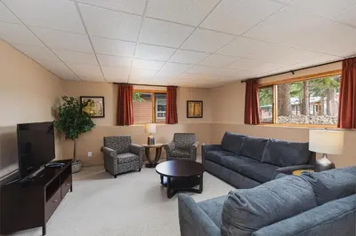 a living room with a couch and a tv at Overlander Mountain Lodge in Jasper