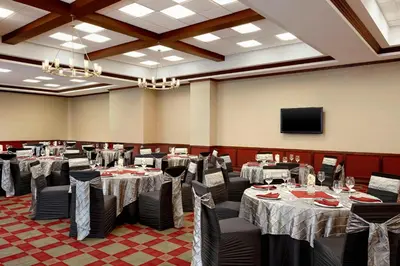 a banquet hall with tables and chairs and a television at Four Points by Sheraton Calgary Airport in Calgary