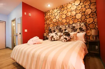 a bedroom with a bed with a large wall of logs at Days Inn by Wyndham Calgary North Balzac in Balzac