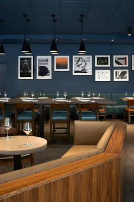 a restaurant with tables and chairs and pictures on the wall at Four Points by Sheraton Surrey in Surrey