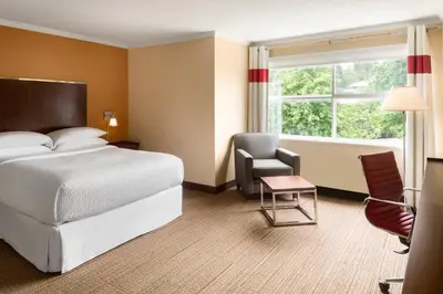 a bedroom with a bed and a chair and a window at Four Points by Sheraton Surrey in Surrey
