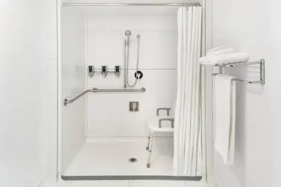 a white bathroom with a shower and a sink at Four Points by Sheraton Surrey in Surrey