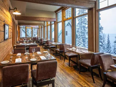 a restaurant with tables and chairs and large windows at Emerald Lake Lodge in Field