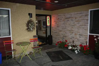 a room with chairs and a table and a door at Hillcrest Motel in Swan Hills