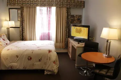 a hotel room with a bed and a television at Hillcrest Motel in Swan Hills