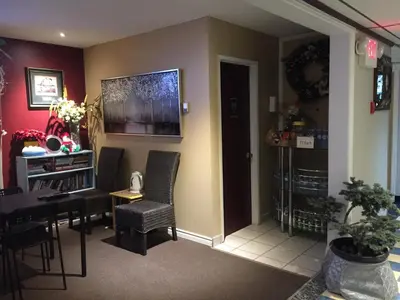 a living room with a table and chairs and a television at Hillcrest Motel in Swan Hills