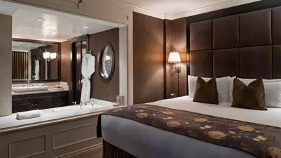 a hotel room with a bed and a bath tub at Wedgewood Hotel & Spa - Relais & Chateaux in Vancouver
