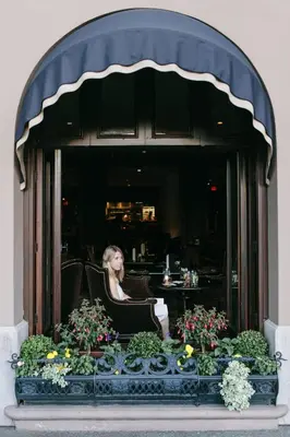 a woman sitting in a chair in front of a window at Wedgewood Hotel & Spa - Relais & Chateaux in Vancouver