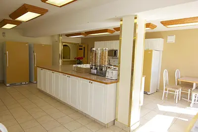 a large kitchen with white cabinets and a counter at Western Budget Motel Bonnyville in Bonnyville