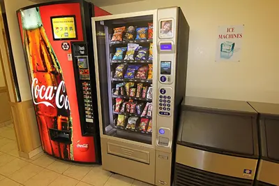 a soda vending machine next to a soda machine at Western Budget Motel Bonnyville in Bonnyville