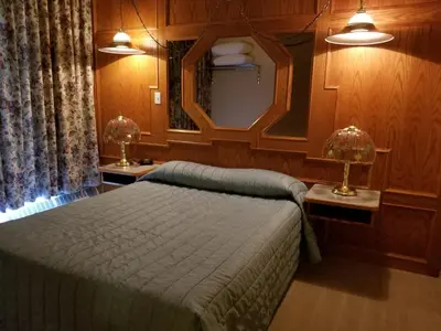 a bedroom with a bed and a mirror and two lamps at New Imperial Inn in Cold Lake
