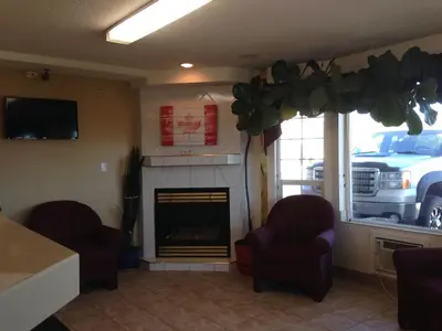 a living room with two chairs and a fireplace at Western Budget Motel Peace River in Peace River