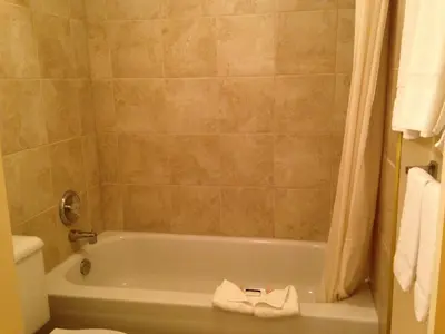 a bathroom with a tub and a toilet at Western Budget Motel Peace River in Peace River