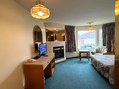 a bedroom with a desk with a television and a fireplace at Western Budget Motel #3 Whitecourt in Whitecourt