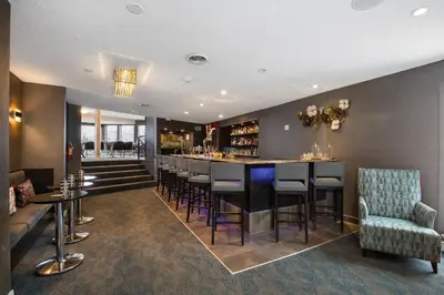 a bar in a restaurant with chairs and a bar counter at Ramada by Wyndham Kamloops in Kamloops